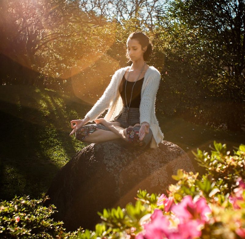 Woman Meditating on Rock